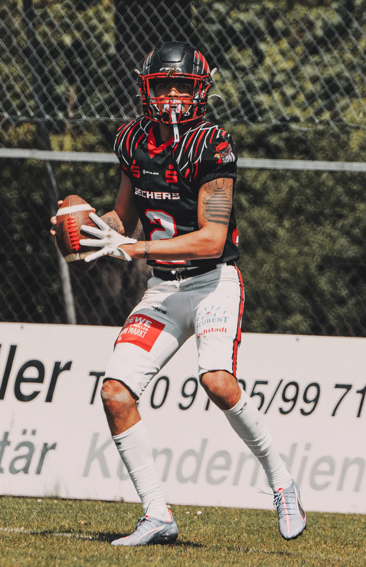 Footballspieler mit Ball auf dem Spielfeld